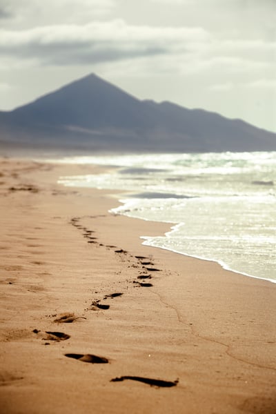footprints-sandy-beach-with-mountain-background-canary-islands-spain